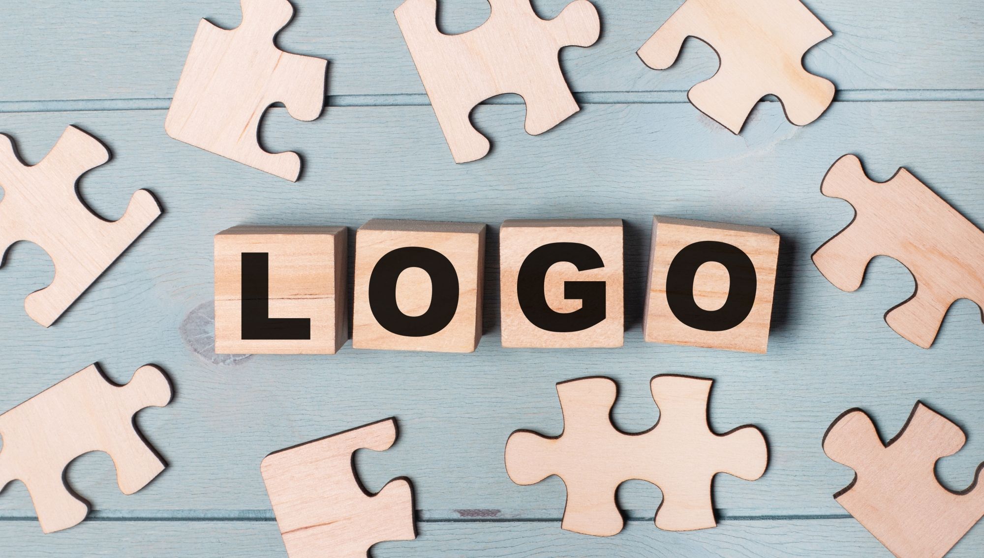 zertifikatslogo-dqs-mit holzkloetzen wird das wort logo abgebildet umkreist von puzzleteilen